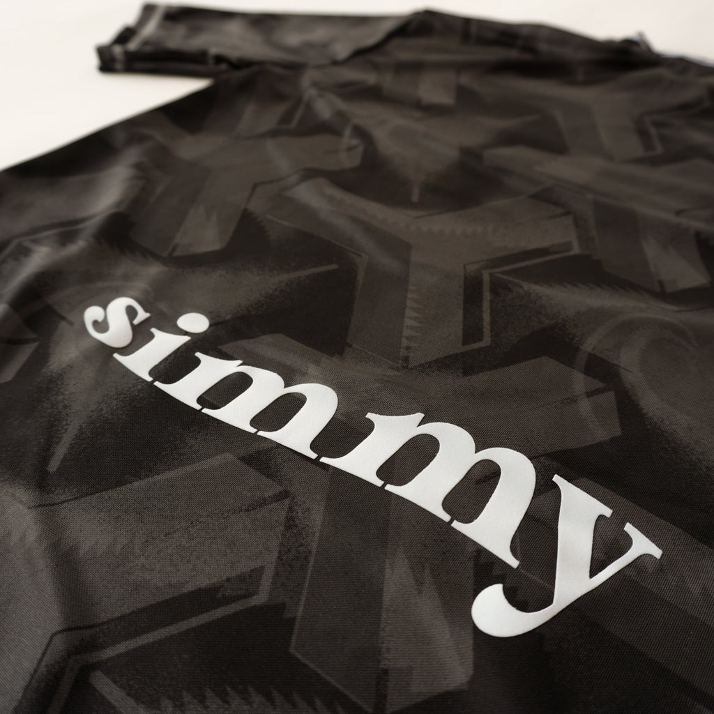 SIMMY Brave New World oversized black jersey featuring a bold all-over graphic pattern and white brand logo text.