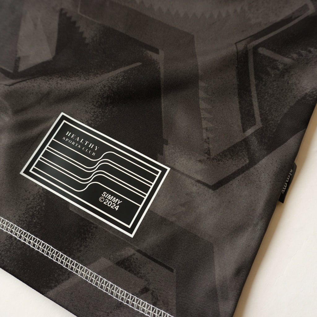 Close-up of the SIMMY Brave New World oversized jersey featuring a black graphic pattern and woven brand patch.