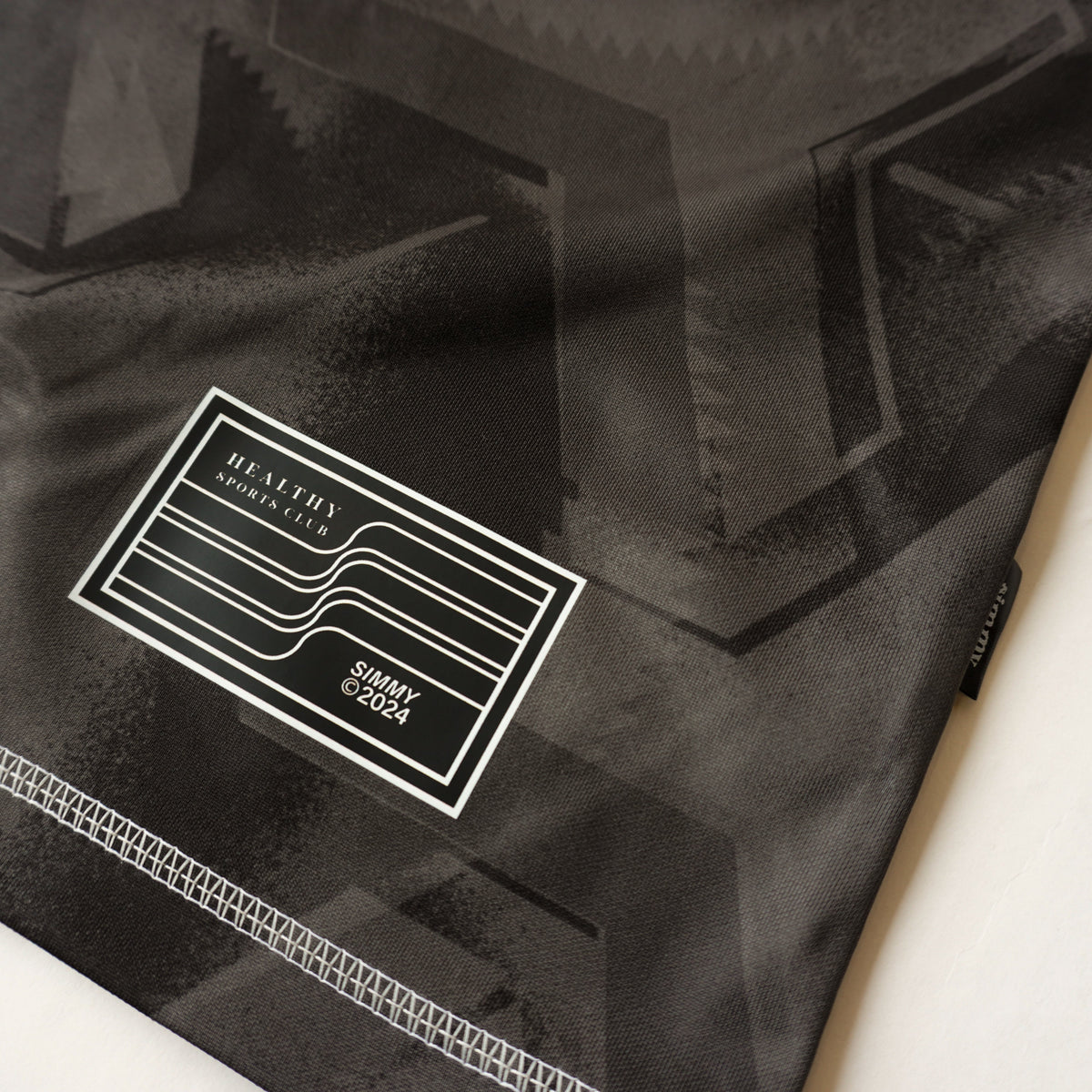 Close-up of the SIMMY Brave New World oversized jersey featuring a black graphic pattern and woven brand patch.