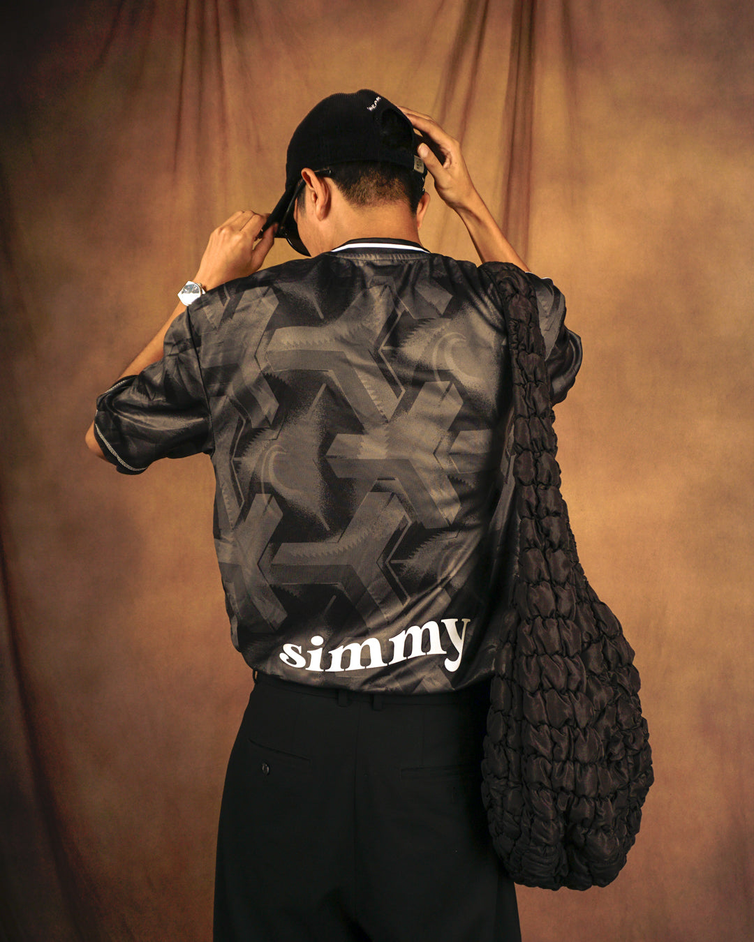 SIMMY Brave New World oversized black jersey with bold graphic pattern and white logo on back, worn by a man.
